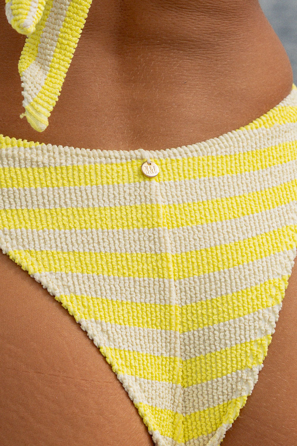 Frau in Bikini Brazilian Hose Gelb Creme gestreift Rückenansicht Detail